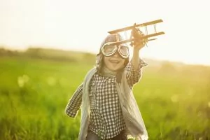 A child playing with a toy plane, free of dental anxiety.