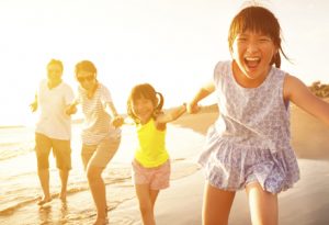 A family of four enjoying fun in the sun at the beach.