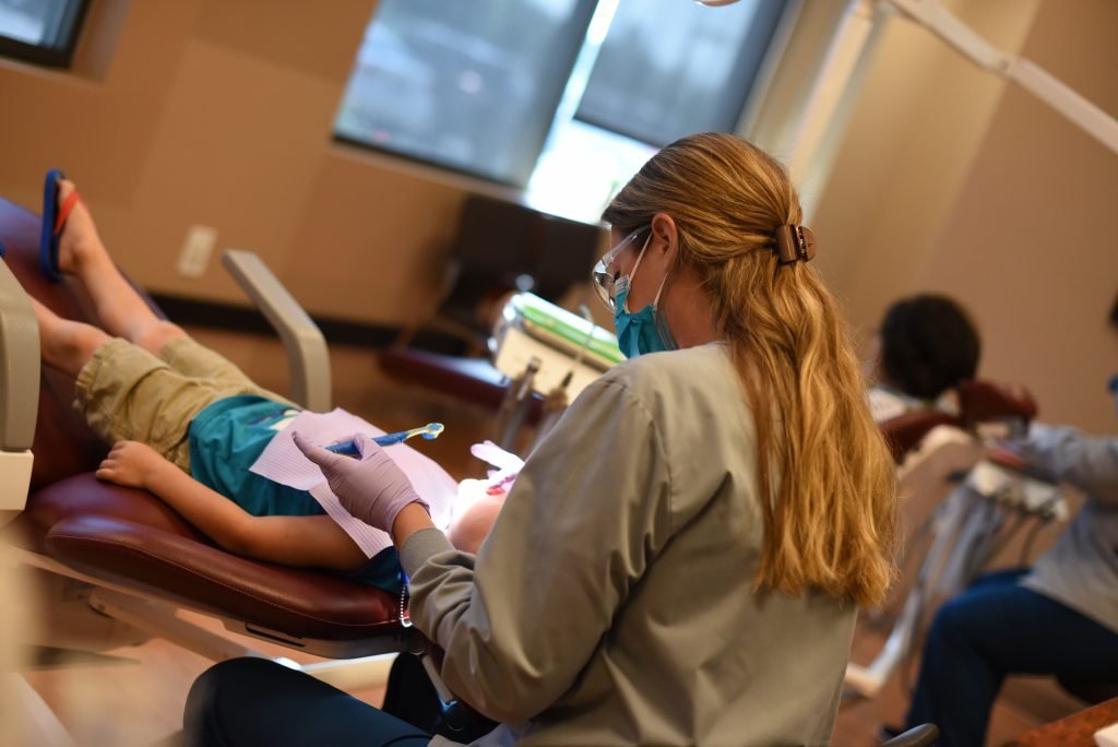 One of Pediatric Dental Center's dental hygienists provides a teeth cleaning to ensure dental health for kids.