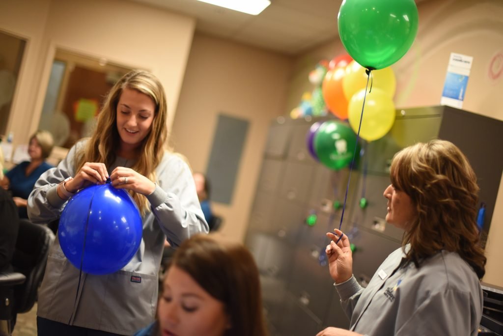 Pediatric Dental Center team blowing up balloons.