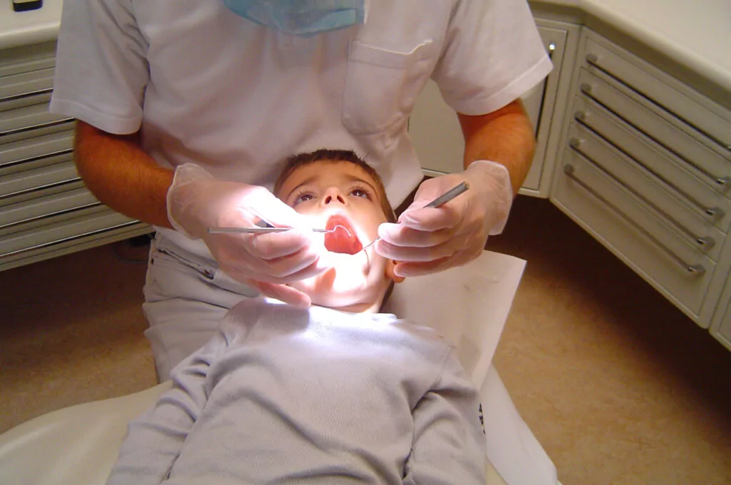 Child receiving a dental examination from a dentist.
