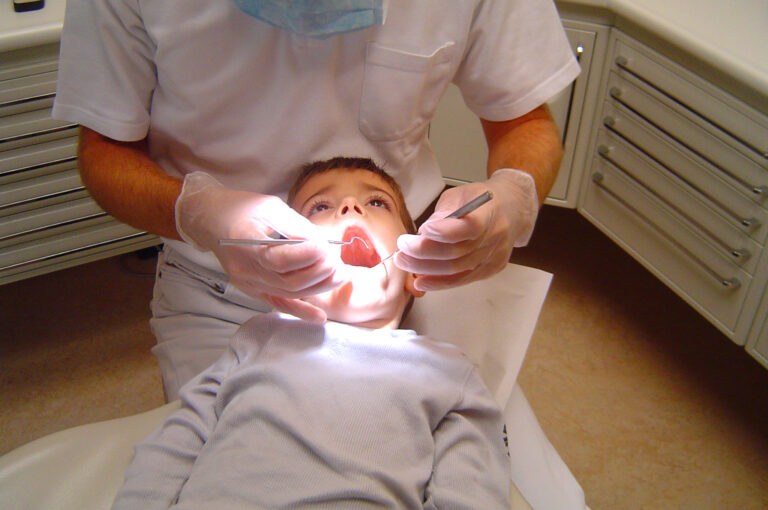 Child receiving a dental examination from a dentist.