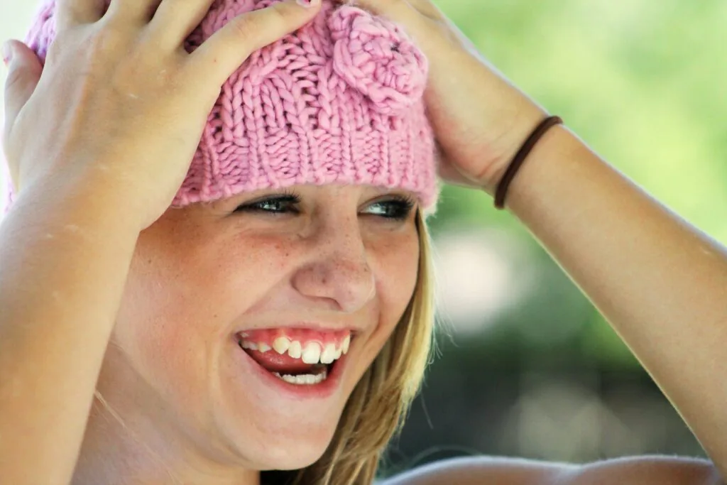 A girl in a pink hat smiling with healthy teeth in Burlington.