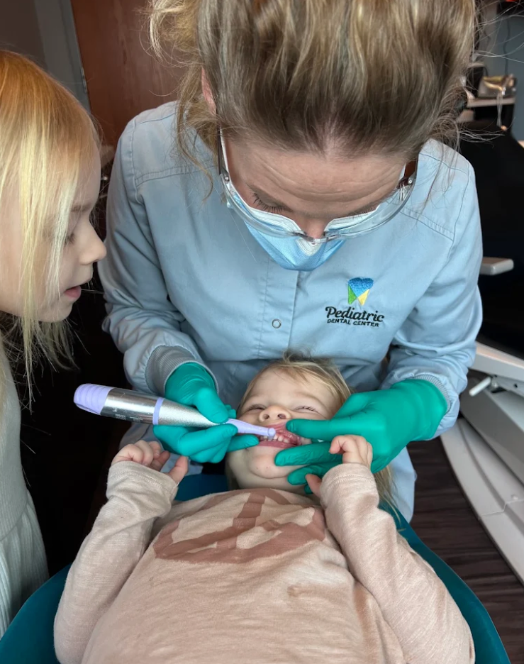 A child learning how to brush teeth properly to prevent gum disease in Kentucky.