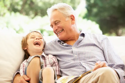A grandfather and grandson laughing with healthy teeth after preventative pediatric dental care in Kentucky.